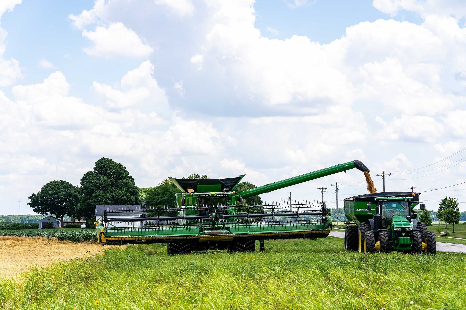A combine unloads wheat into a grain cart during harvest in Brownsburg, Indiana, June 2021 (USDA NRCS photo by Brandon O’Connor)