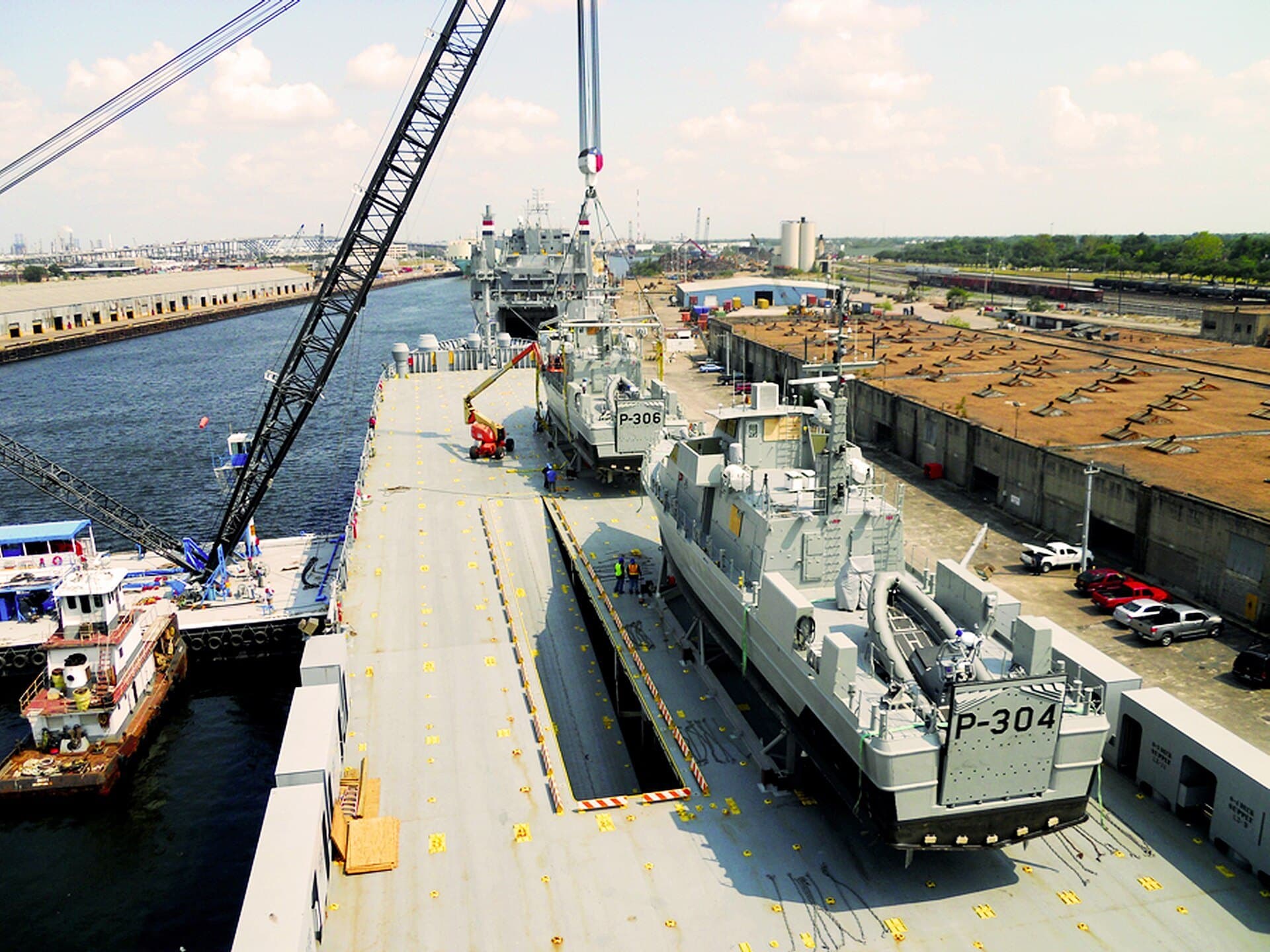 Crane loading U.S.-built patrol boats onto a Maritime Administration Ready Reserve Force ship