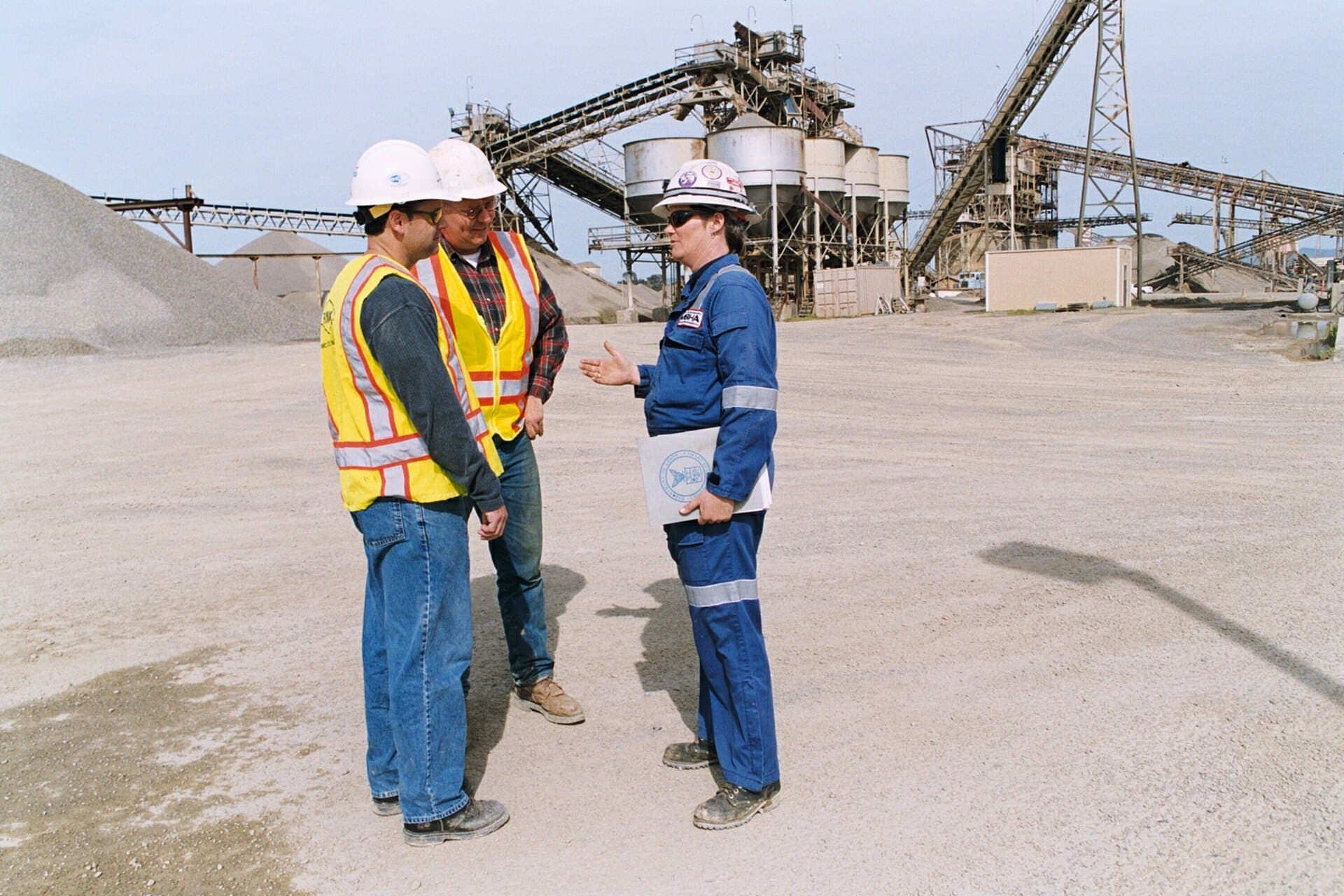 MSHA inspector in hard hat and safety vest talking with workers at a California mine site