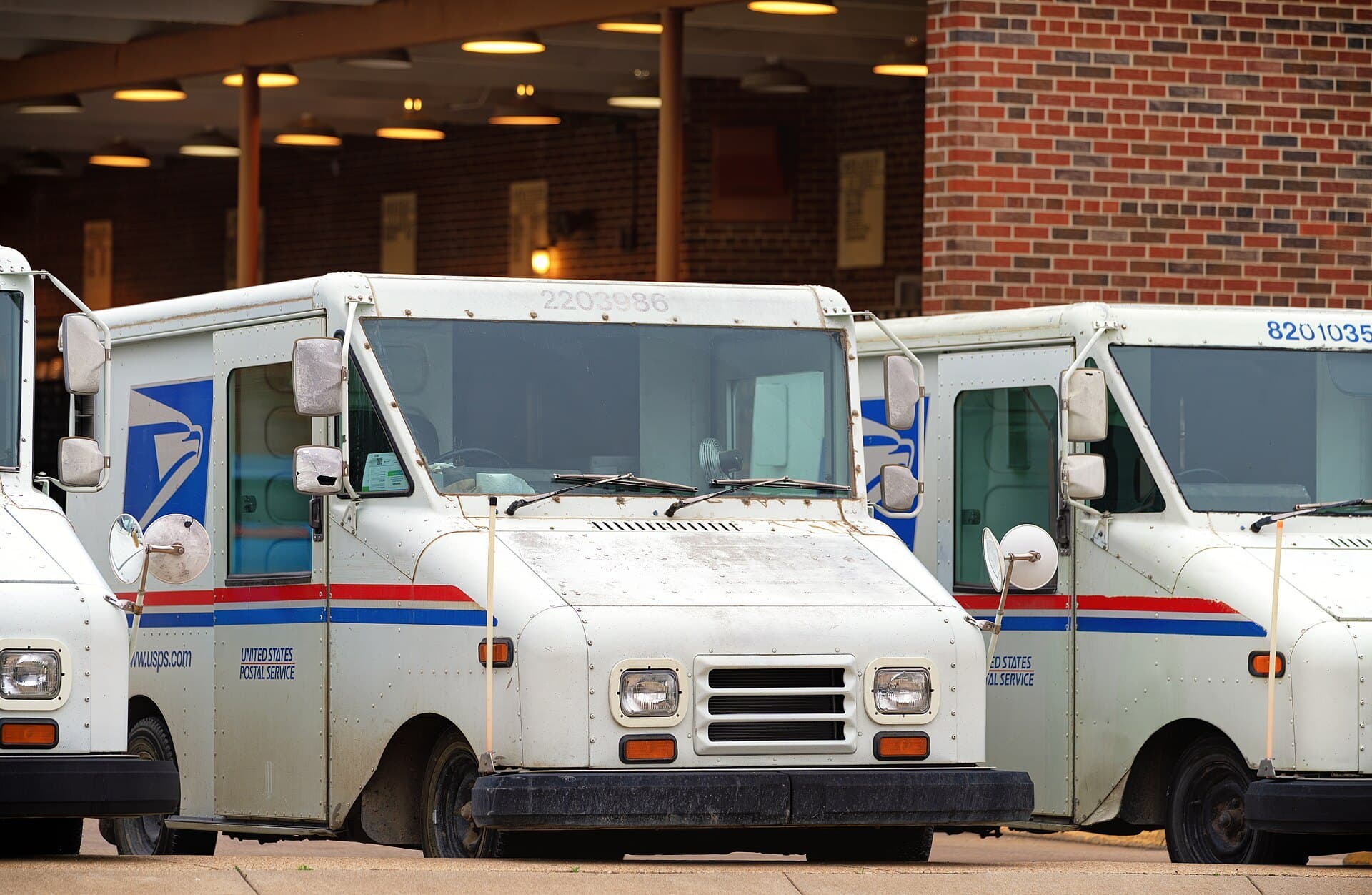 U.S. Postal Service mail delivery trucks parked outside the post office in Hays, Kansas