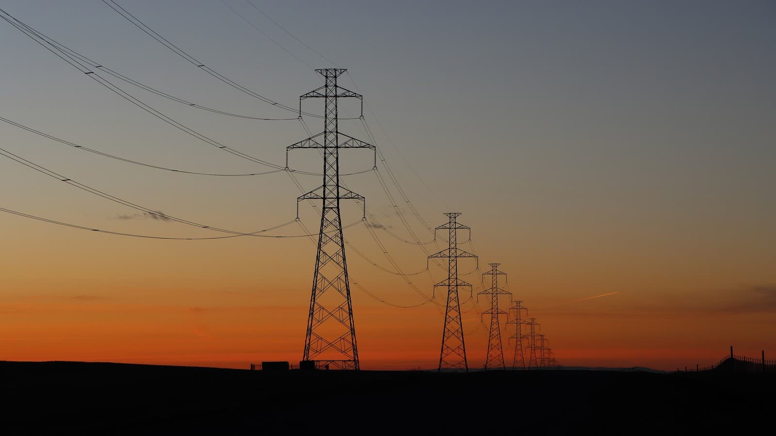 Transmission lines at sunset (illustrative file photo; not a specific PJM facility).