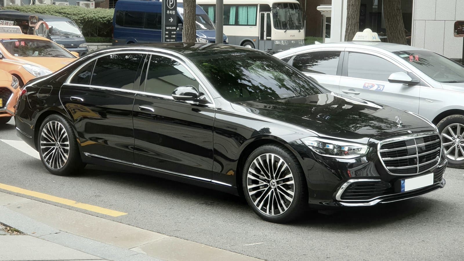 Black Mercedes-Benz S 580 S-Class sedan (W223 generation) parked at a city curb, seen from the front right